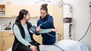 Julianna Montoya taking a patient's blood pressure